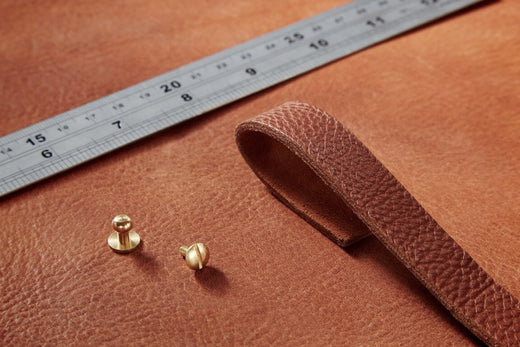 Vegetable tanned leather piece with ruler and brass press studs