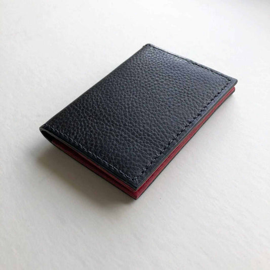 Hand stitched black leather bifold card wallet by CARV with pebble texture, shown closed.