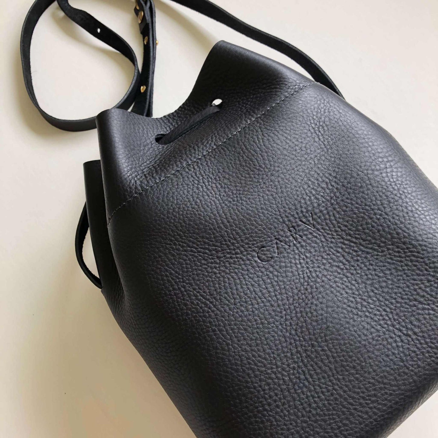 Nomad Midi Black Leather Bucket Bag by CARV, handcrafted from sustainable leather, featuring a minimalist design and adjustable strap.