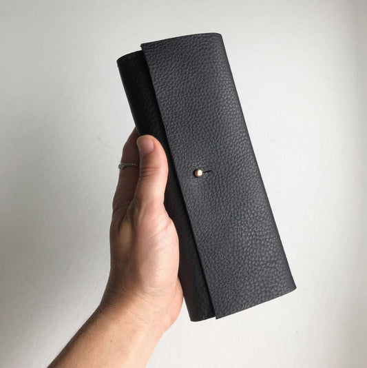 Nomad Midi Leather Folding Wallet in black, handcrafted in sustainable leather with brass closure.