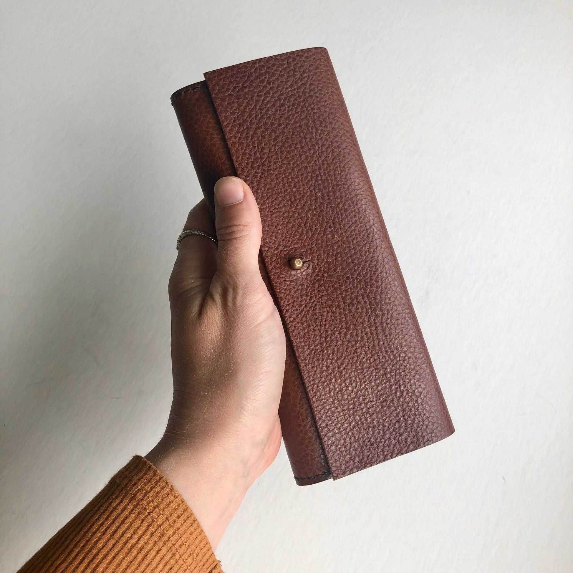 Nomad Midi Leather Folding Wallet in tan, handcrafted in sustainable vegetable-tanned leather, features card slots, zip pocket, and brass closure.