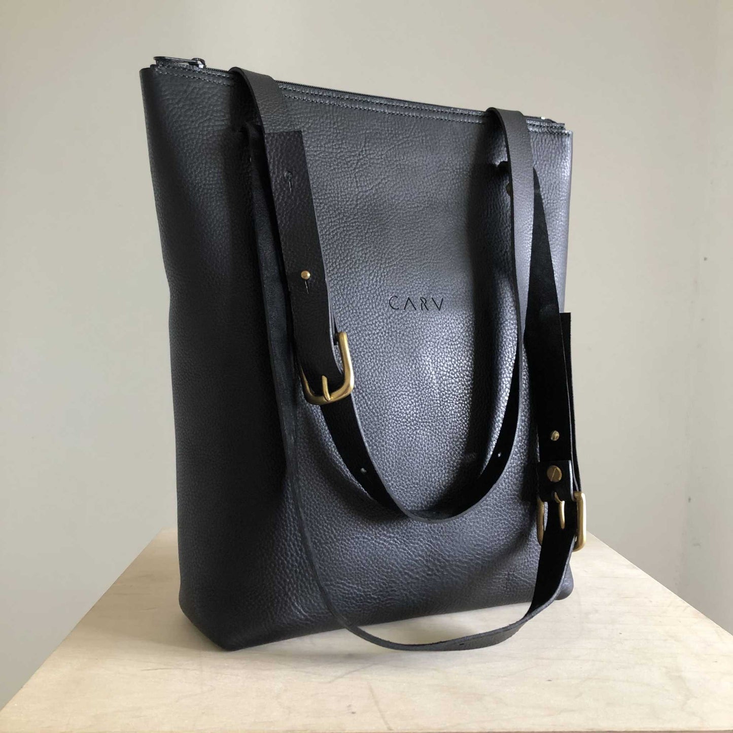 Nomad Black Leather Shopper Bag with adjustable straps, crafted from sustainable leather.