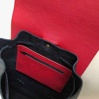 Interior view of Nomad Black Leather Backpack with red lining and zip pocket.