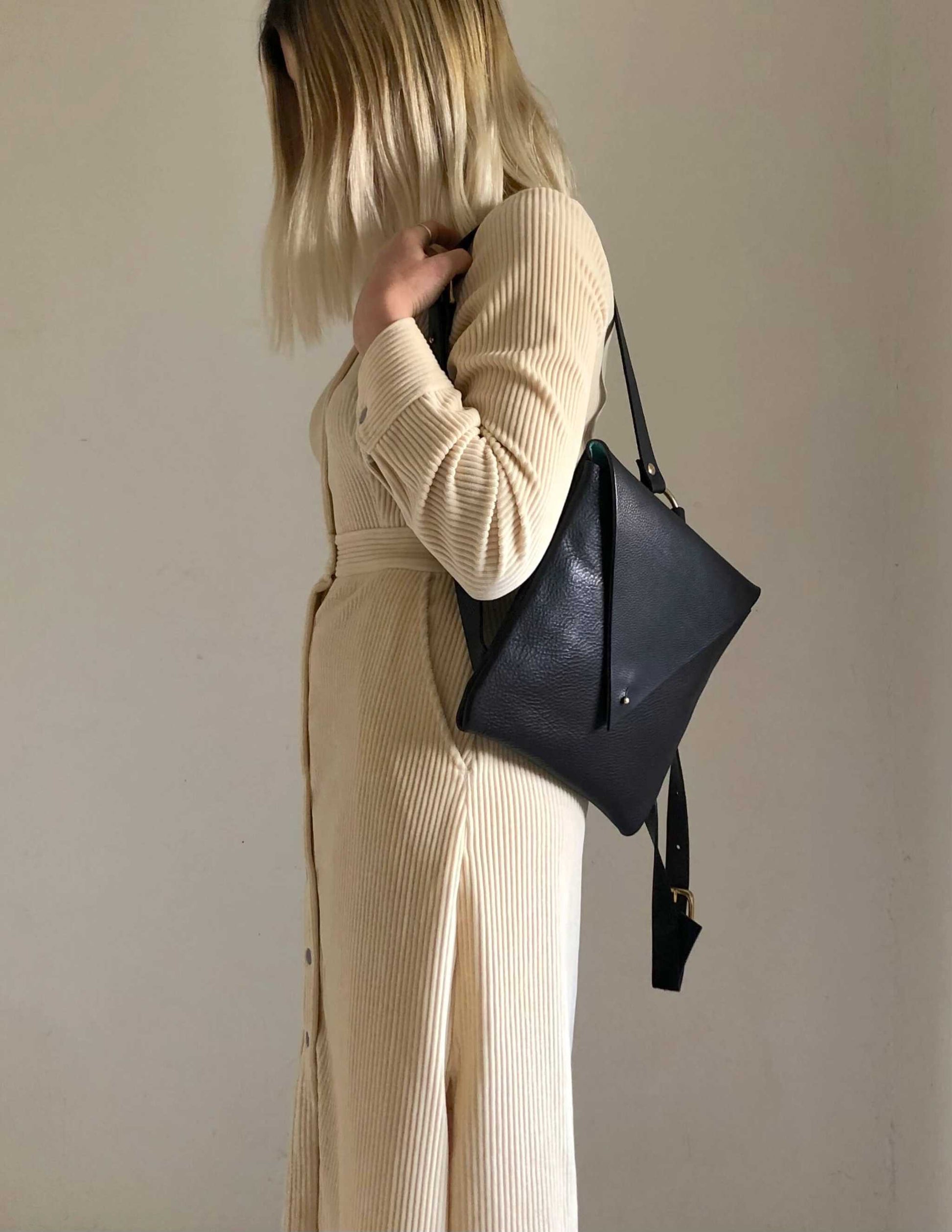 Woman wearing a black Drifter Leather Backpack with minimalist design