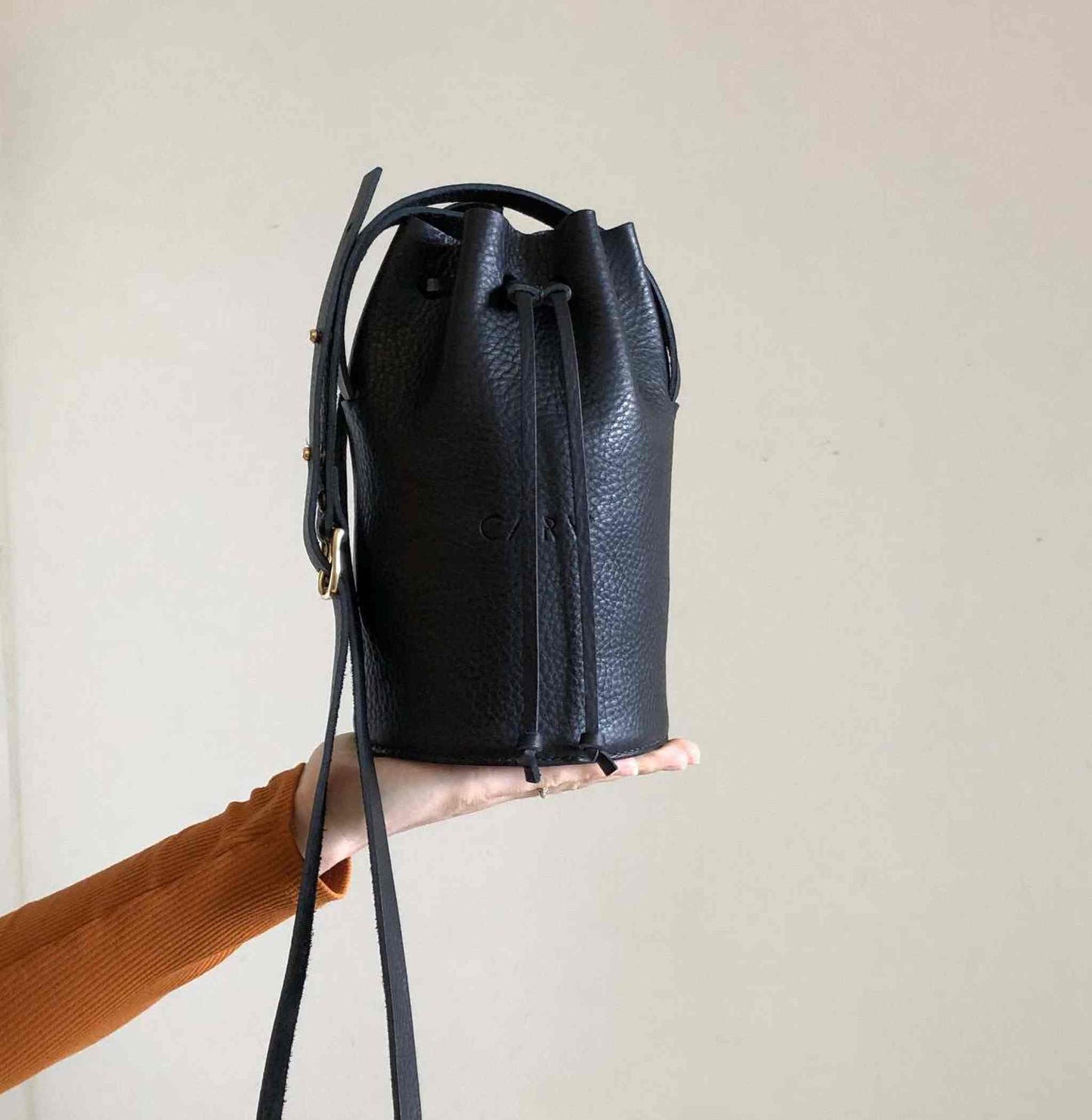 Cylinder Mini Leather Bucket Bag in black, minimalist design, handcrafted sustainable leather, adjustable strap, by CARV.