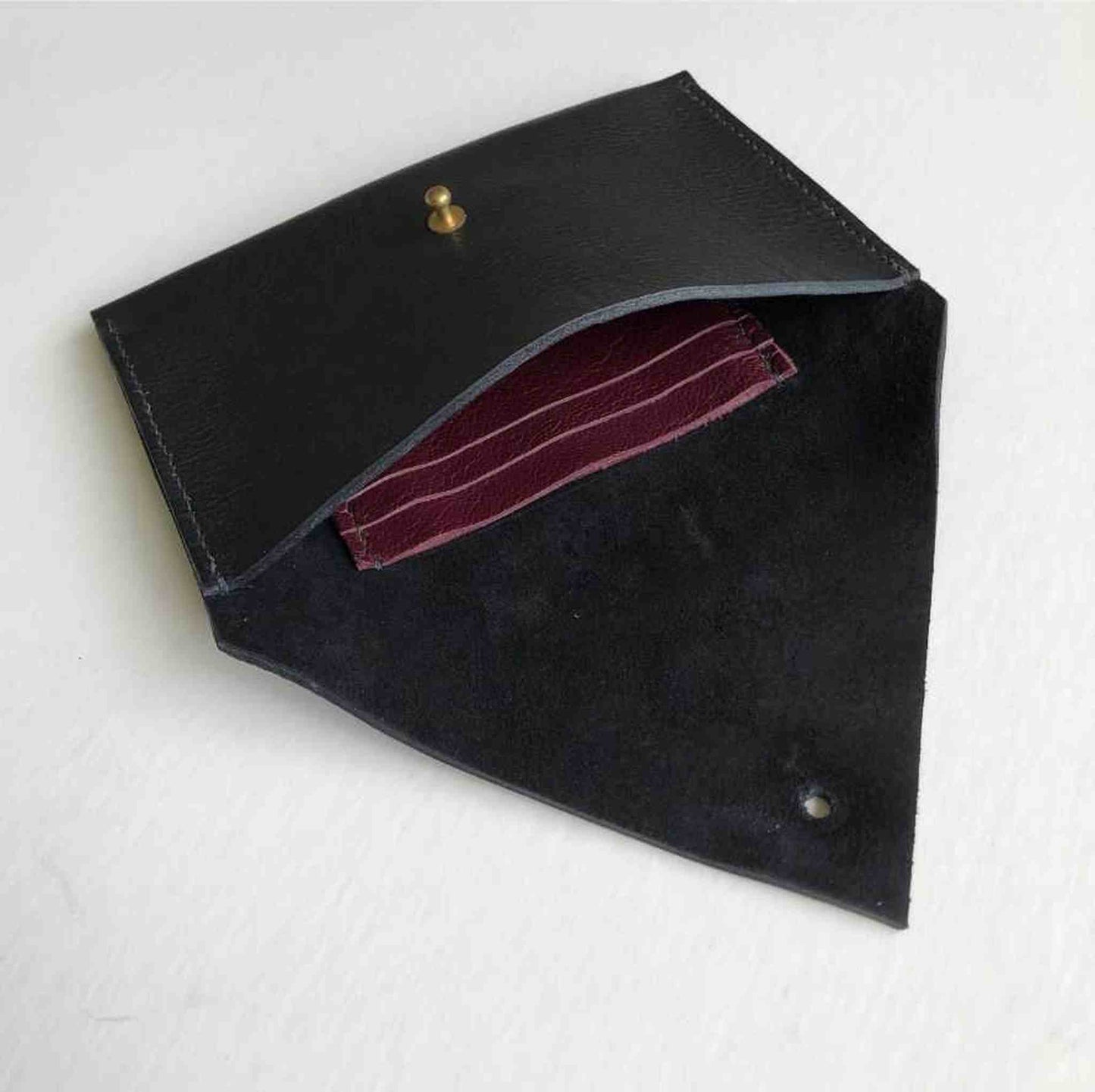 Drifter Maxi Leather Purse Wallet in black shown open with brass press stud, revealing burgundy card holder inside.