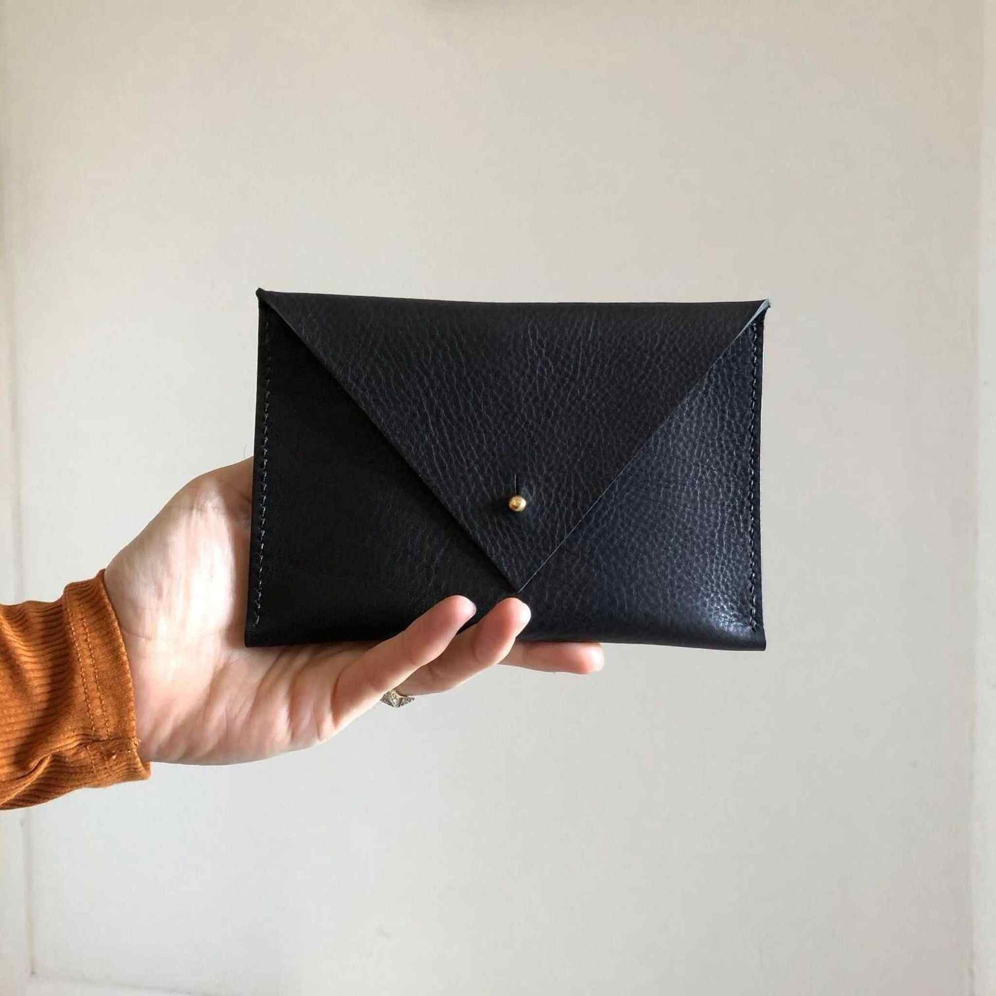 Drifter Maxi Leather Purse Wallet in black with triangle flap and brass closure, made from sustainably sourced vegetable-tanned leather.