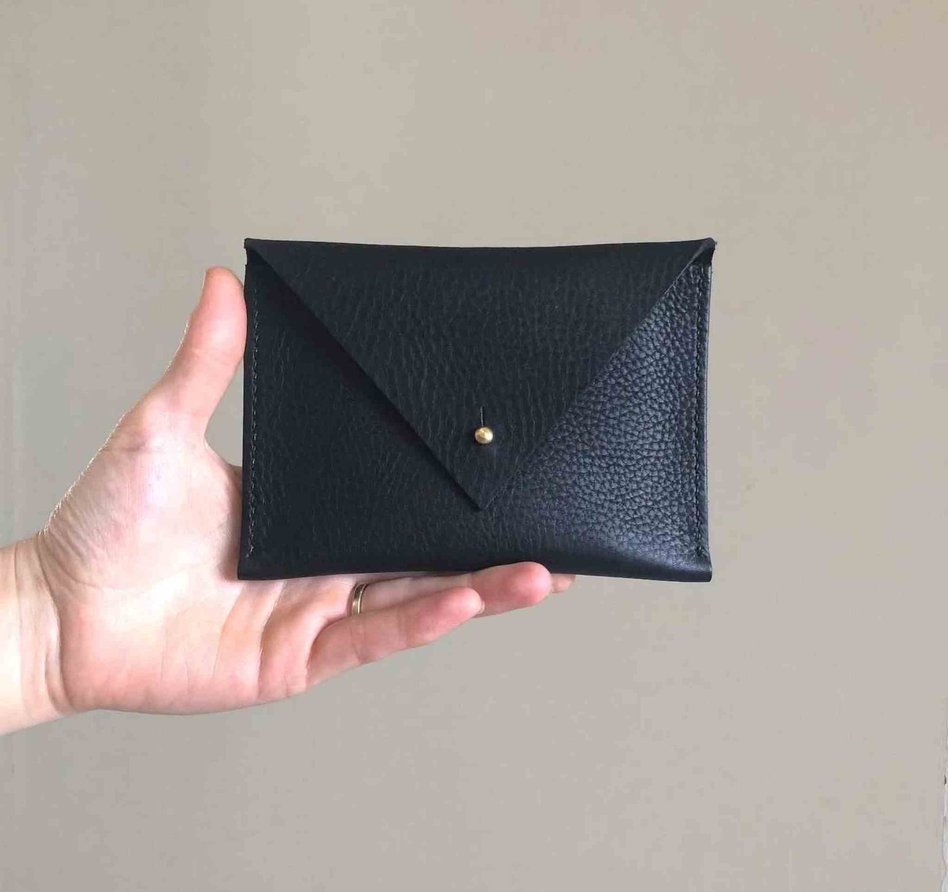 Drifter Midi Leather Purse in black with triangle flap and brass stud.