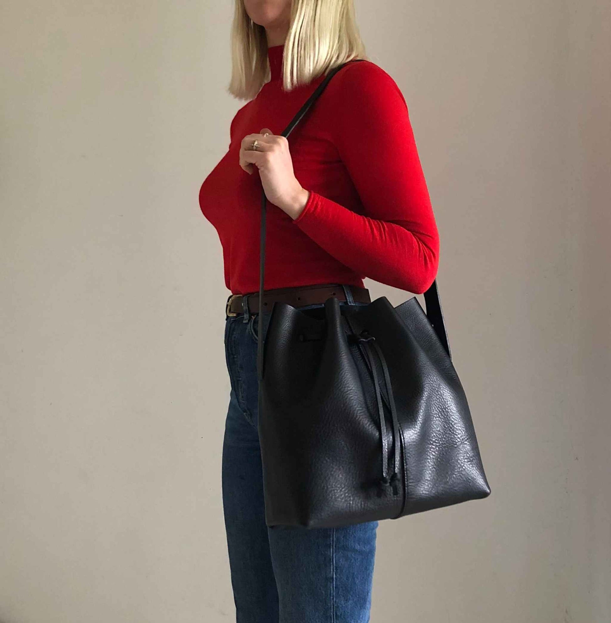 Nomad Maxi Leather Bucket Bag in black, worn crossbody; spacious and elegant design.