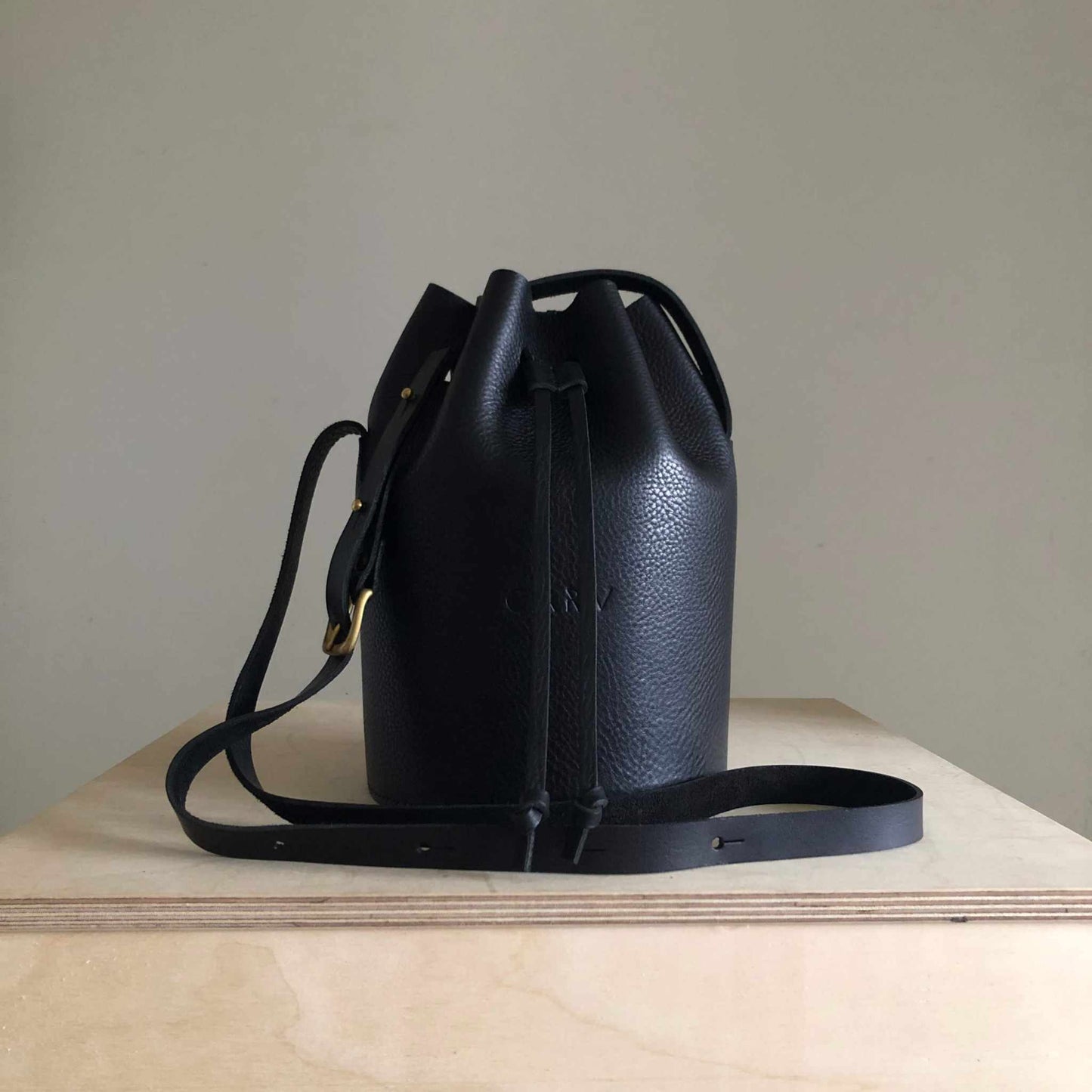 Black Cylinder Leather Bucket Bag with adjustable strap, handcrafted in the UK from eco-friendly vegetable-tanned leather.