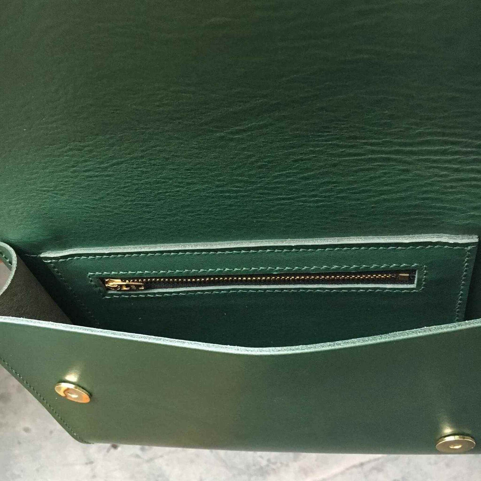 Inside view of the Pioneer Midi Green Leather Crossbody Bag with zip pocket and press stud fastening.