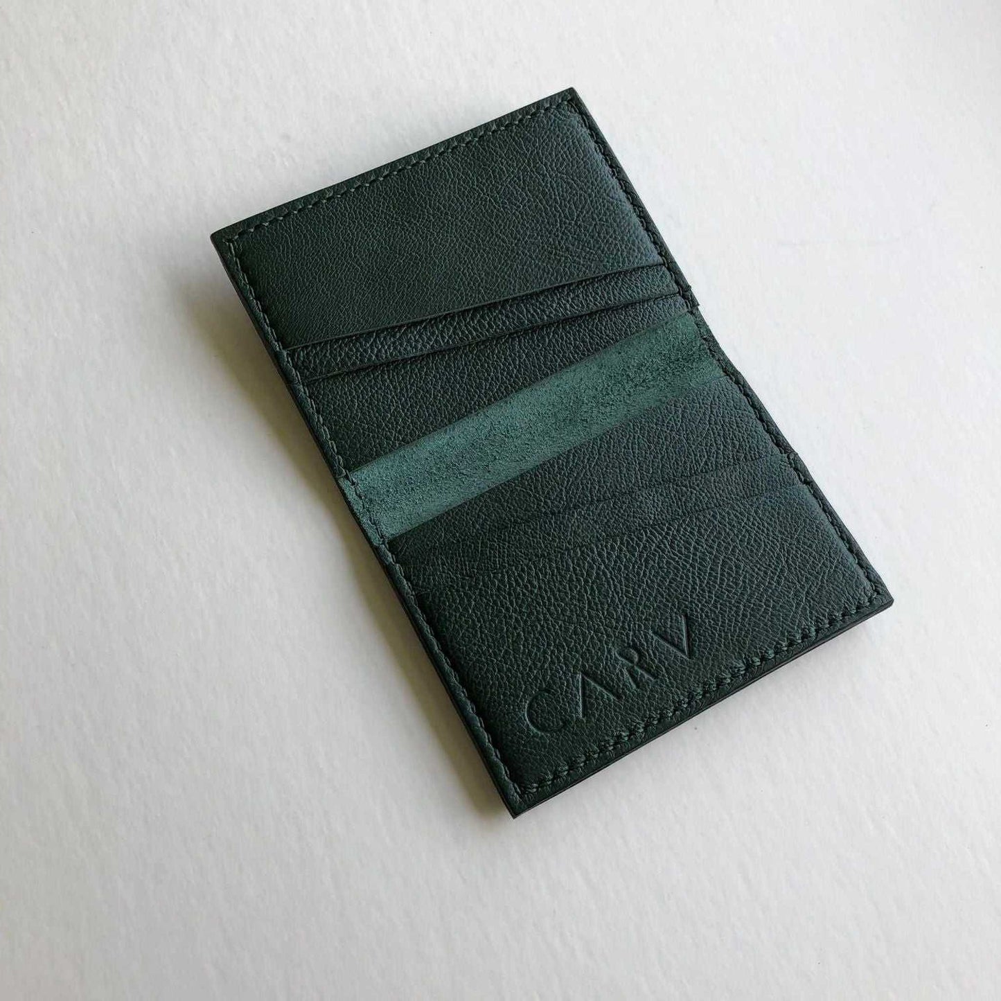 Personalised green leather card wallet, handcrafted in the UK, featuring four card slots and a pocket for folded banknotes.