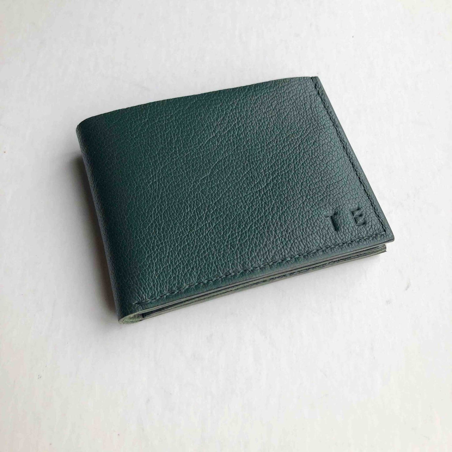 Forest green handmade leather wallet, minimalist design, premium craftsmanship, eco-friendly, bifold style.