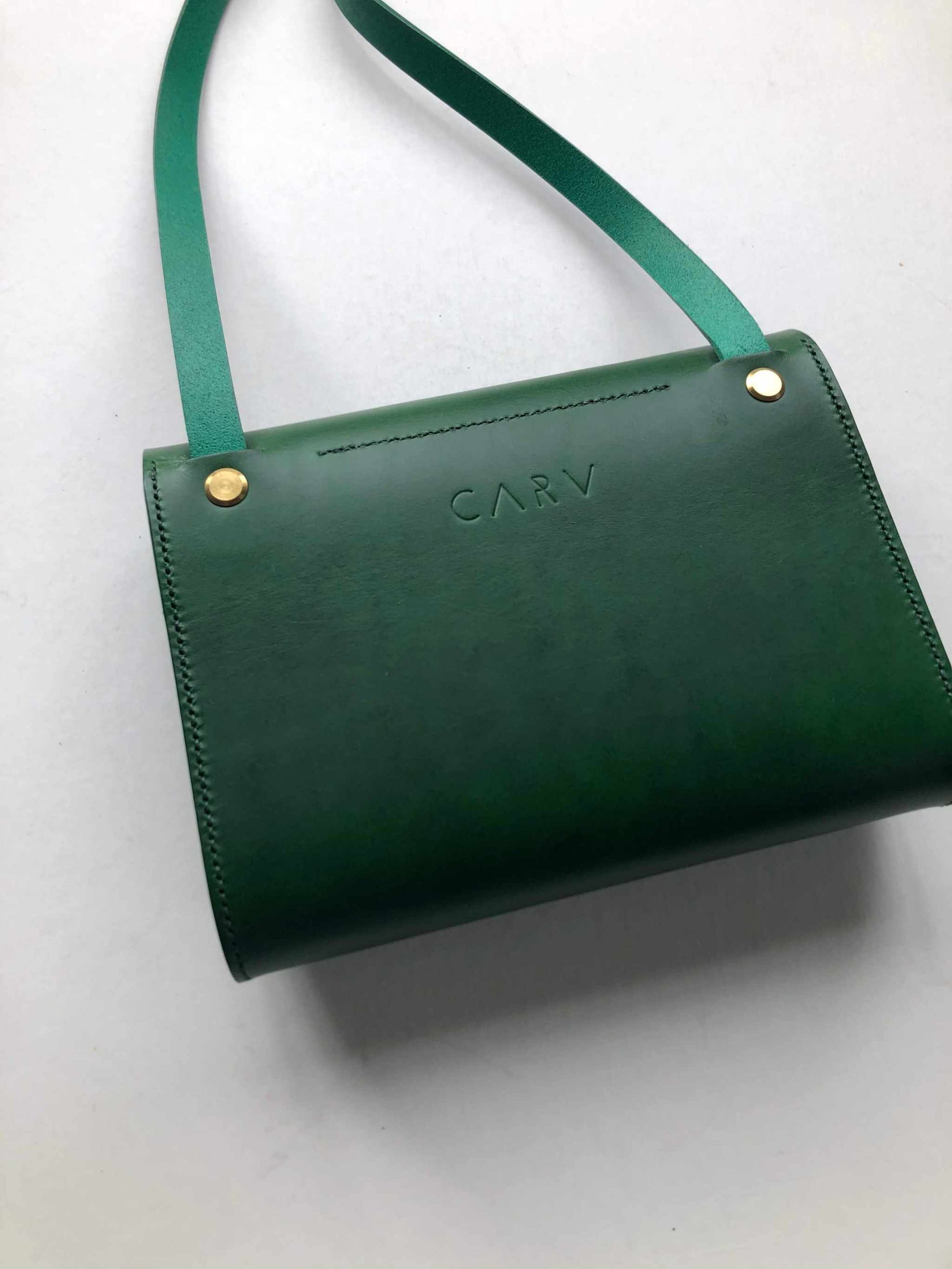 Mini green leather crossbody bag with adjustable strap and sustainable vegetable-tanned leather.