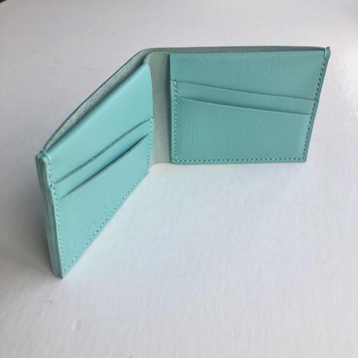 Handmade turquoise leather bifold wallet with card slots, crafted in the UK.