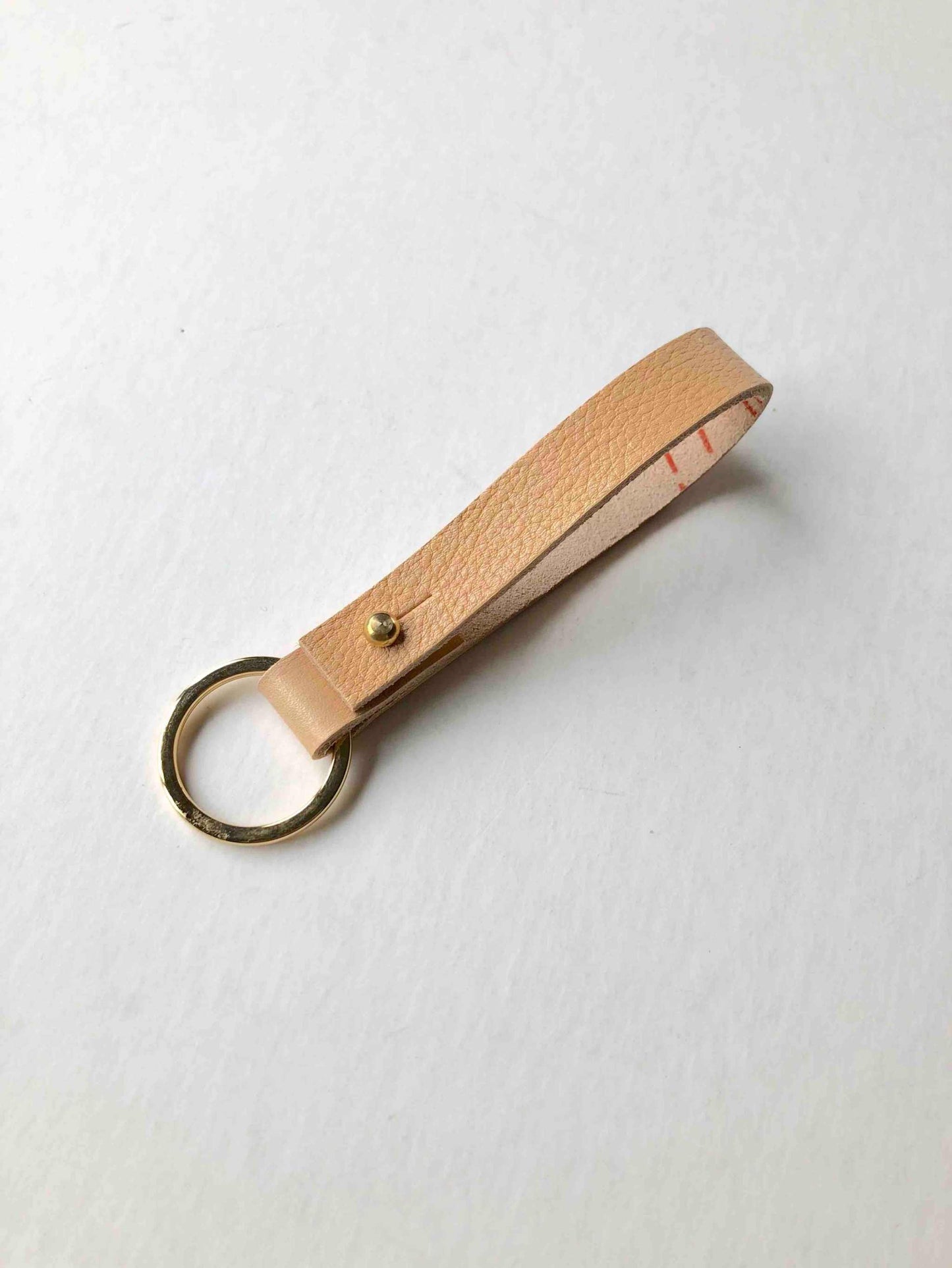 Nomad Personalised Leather Keyring in natural leather color with brass ring and closure.