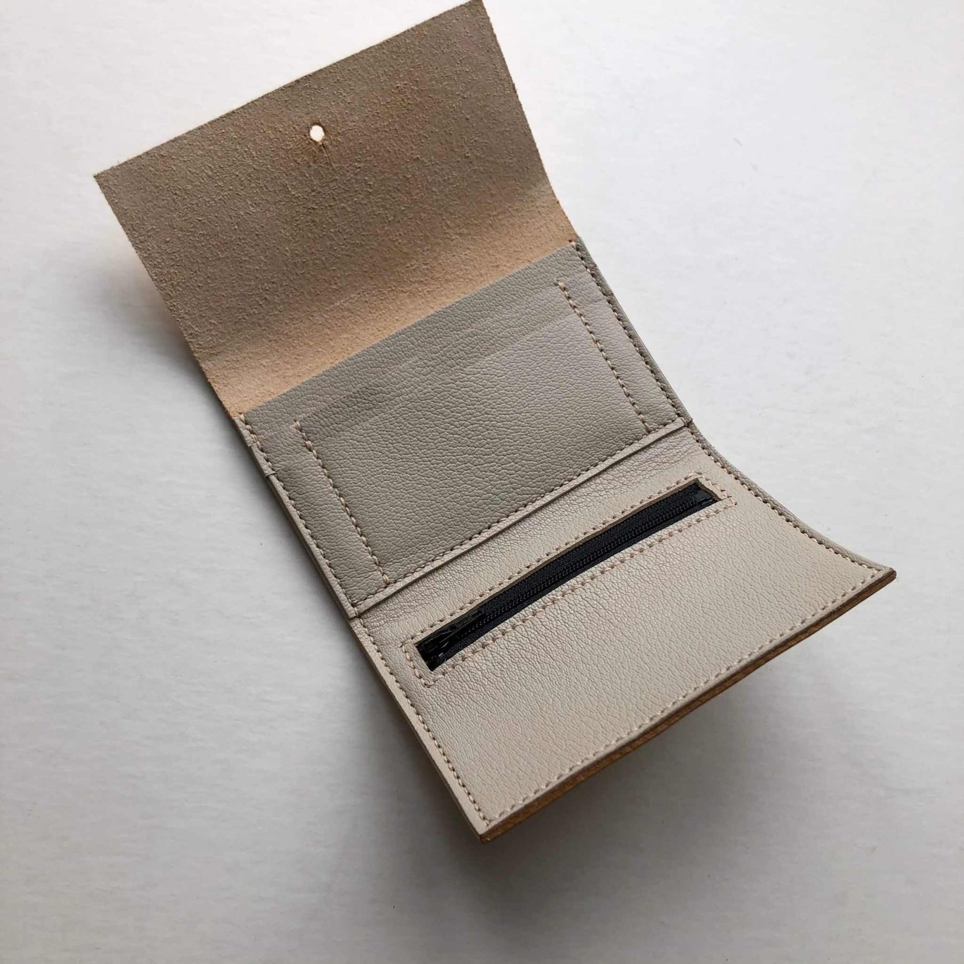 Nomad Mini Handmade Leather Wallet in nude, open view showing card slots and zip pocket.