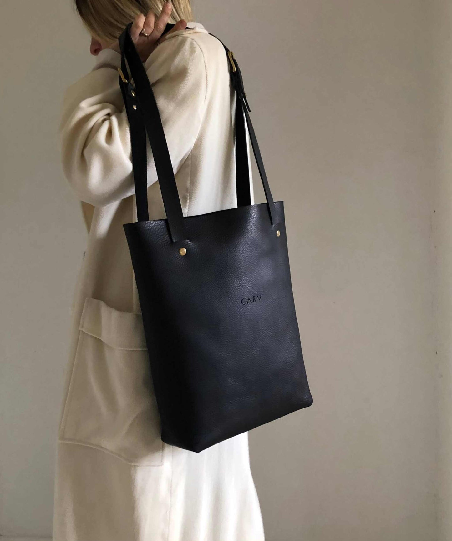 Nomad Black Leather Shopper Bag in minimalist design, handcrafted in the UK with adjustable straps and sustainable materials.