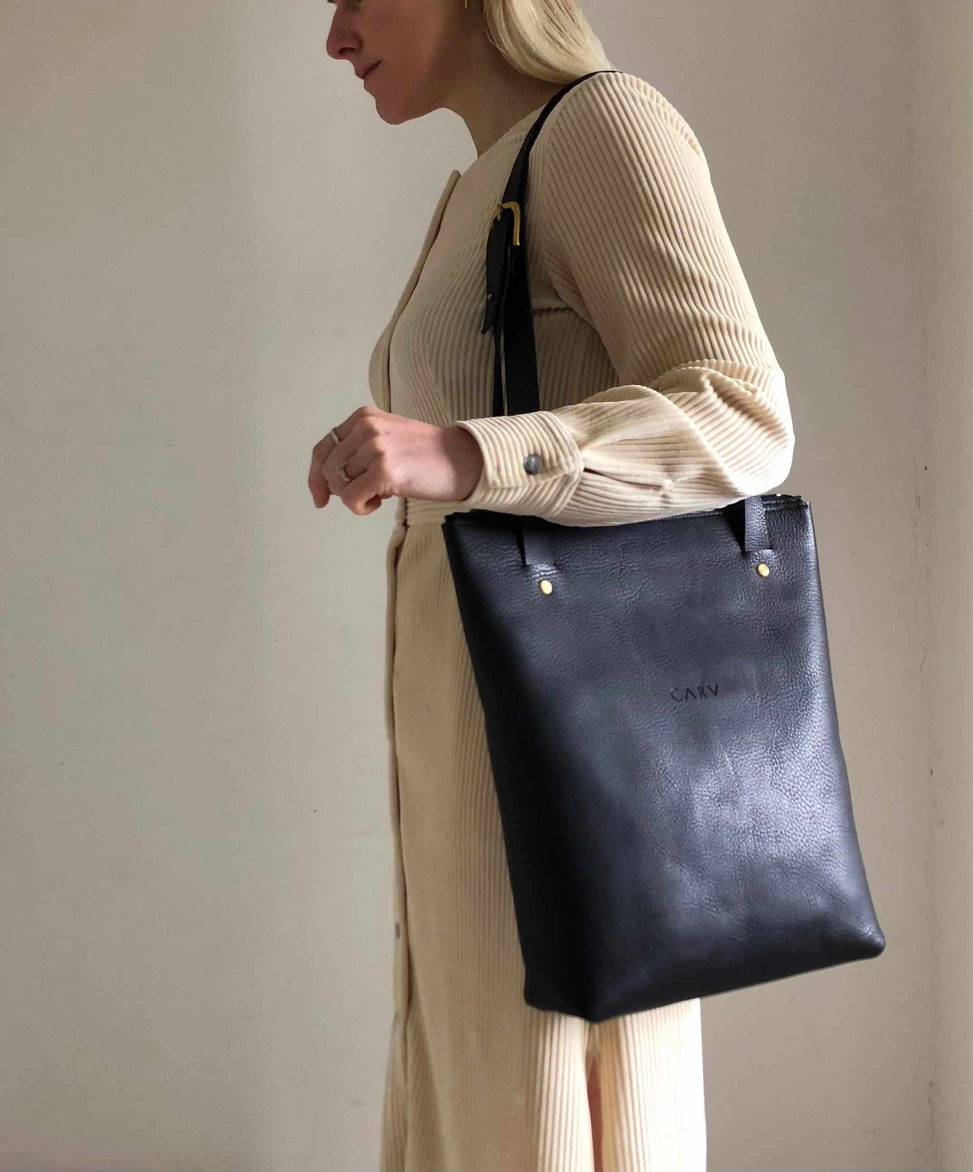 Minimalist Nomad Black Leather Shopper Bag with adjustable straps, showcasing British craftsmanship and sustainable materials.