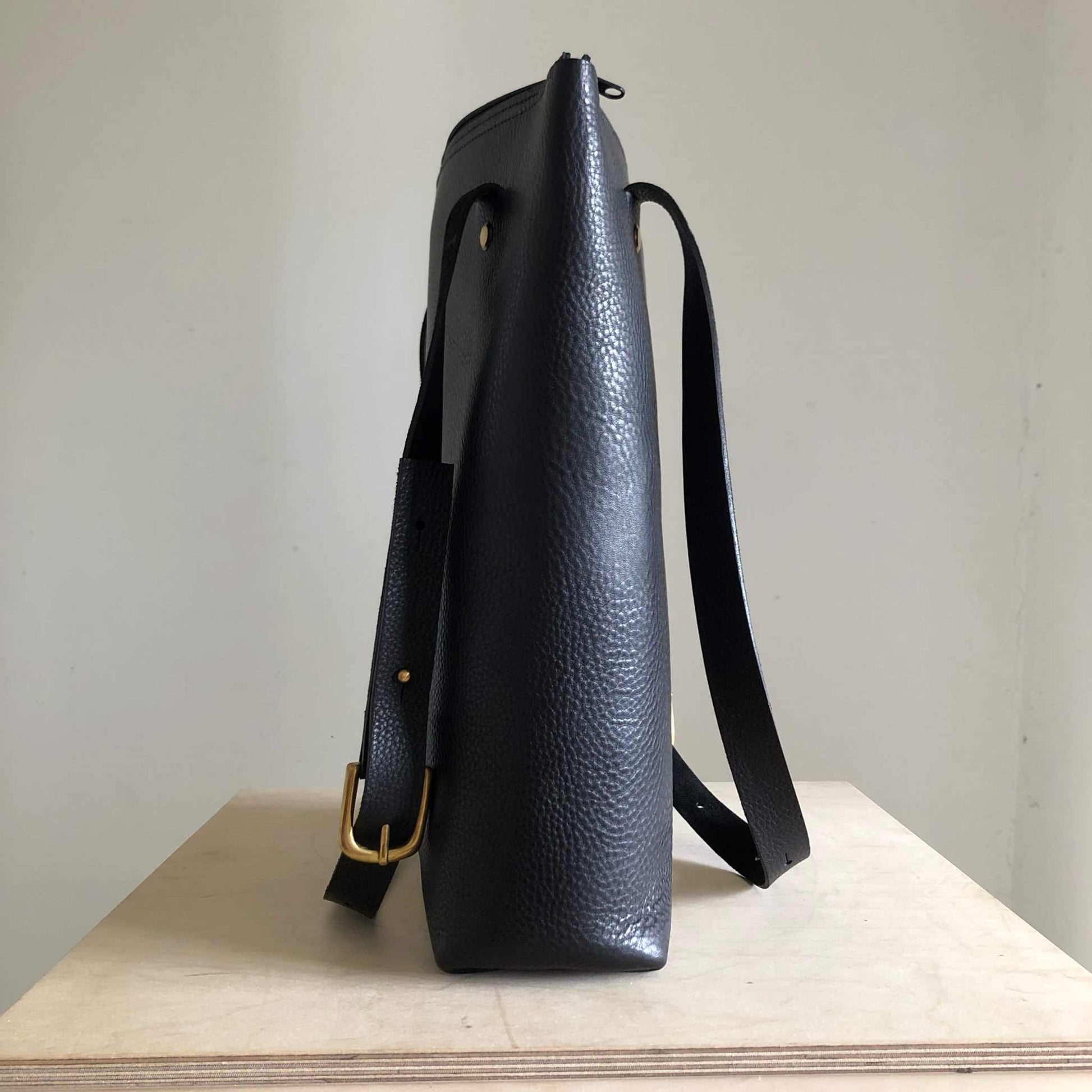 Nomad Black Leather Shopper Bag with adjustable strap, minimalist design, crafted from vegetable-tanned leather.