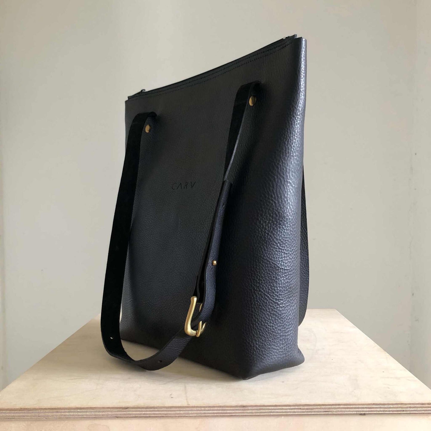 Nomad Black Leather Shopper Bag with adjustable straps, minimalist design, and sustainably sourced leather.