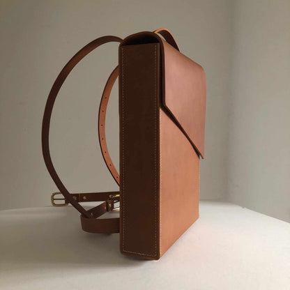 Minimalist Pioneer Tan Leather Backpack with adjustable straps and sleek design.