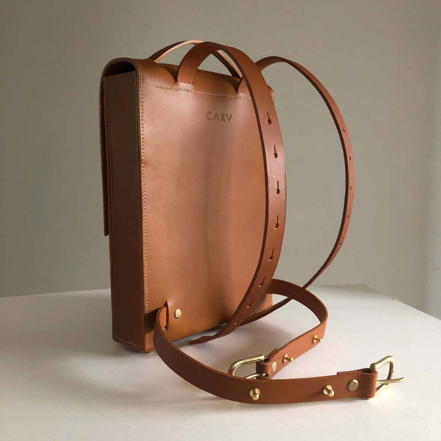 Minimalist Pioneer Tan Leather Backpack with adjustable straps and smooth matte finish.