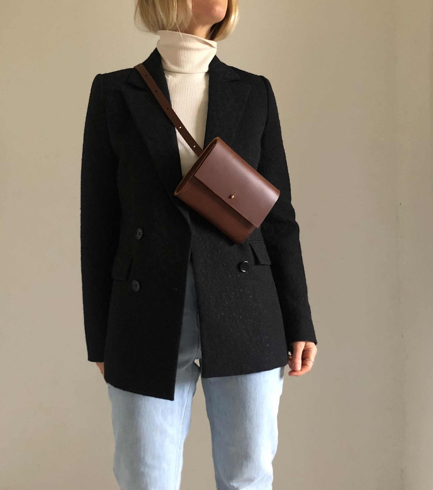 Sedna Tan Leather Belt Bag worn crossbody over black blazer and jeans.