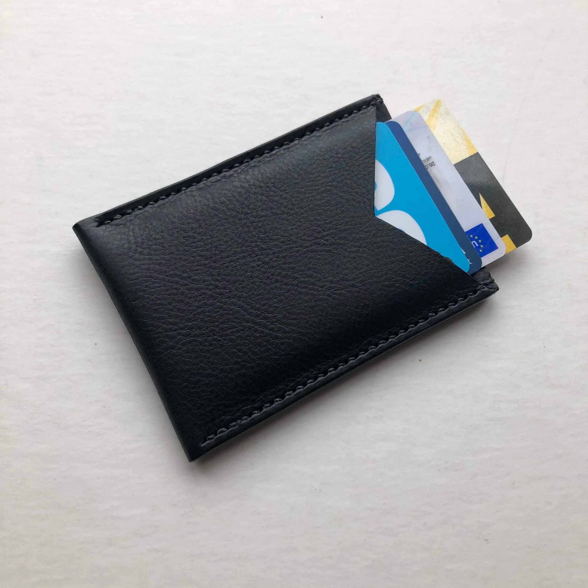 Nomad Leather Card Wallet Sleeve in black with cards, minimalist design, compact functionality.