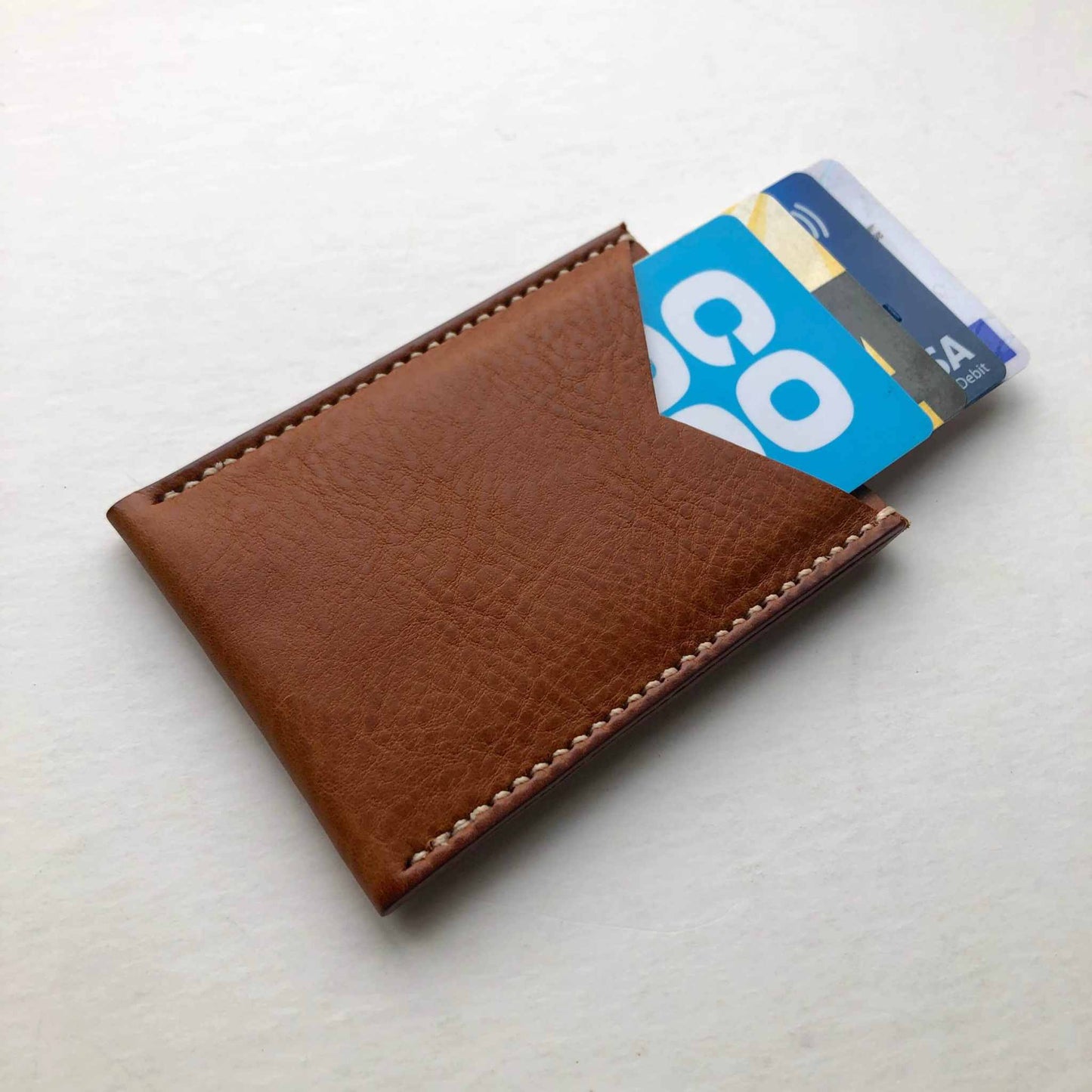 Nomad Leather Card Wallet Sleeve in tan color with credit cards inserted.