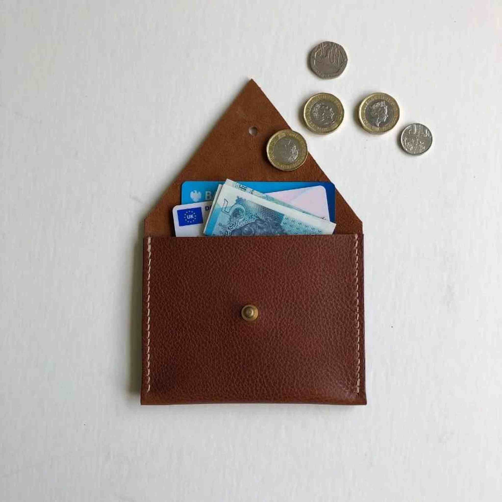 Drifter Mini Leather Coin Purse in red or green, minimalist design, sustainable UK-made, vegetable-tanned leather, brass press stud, compact and versatile accessory.