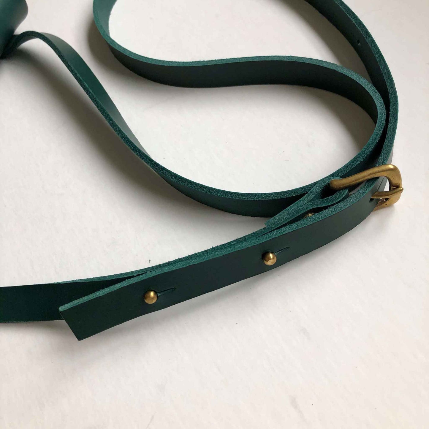 Pioneer Midi Green Leather Crossbody Bag with adjustable strap and brass buckle.