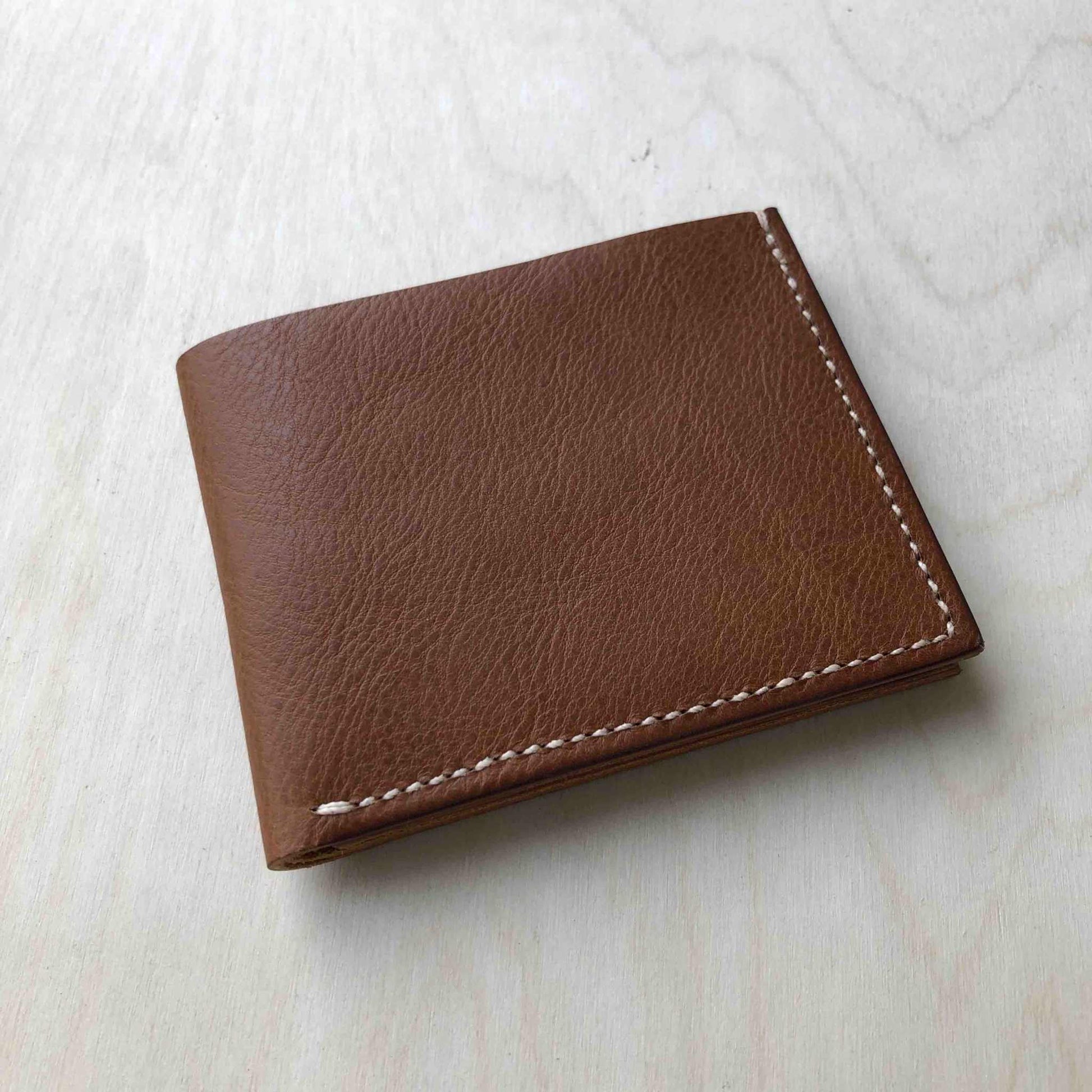 Handmade tan leather wallet with refined style and sustainable craftsmanship.