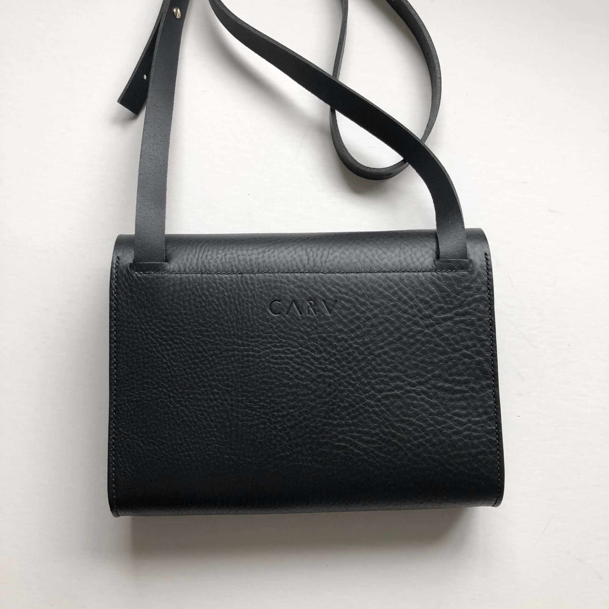 Black leather crossbody bag with adjustable strap and asymmetrical flap.