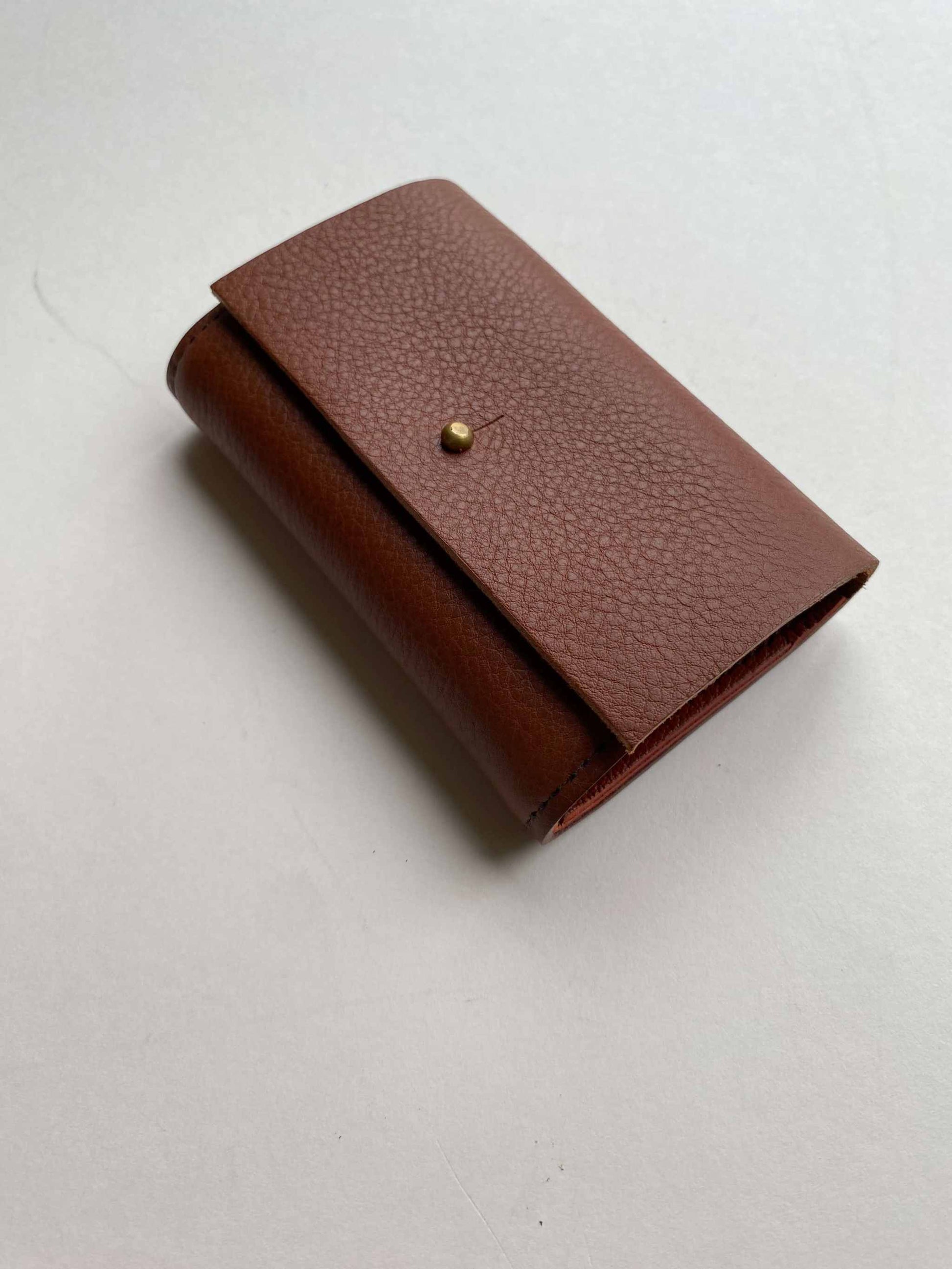 Nomad Mini Handmade Leather Wallet in Tan, folded, with brass press stud closure.