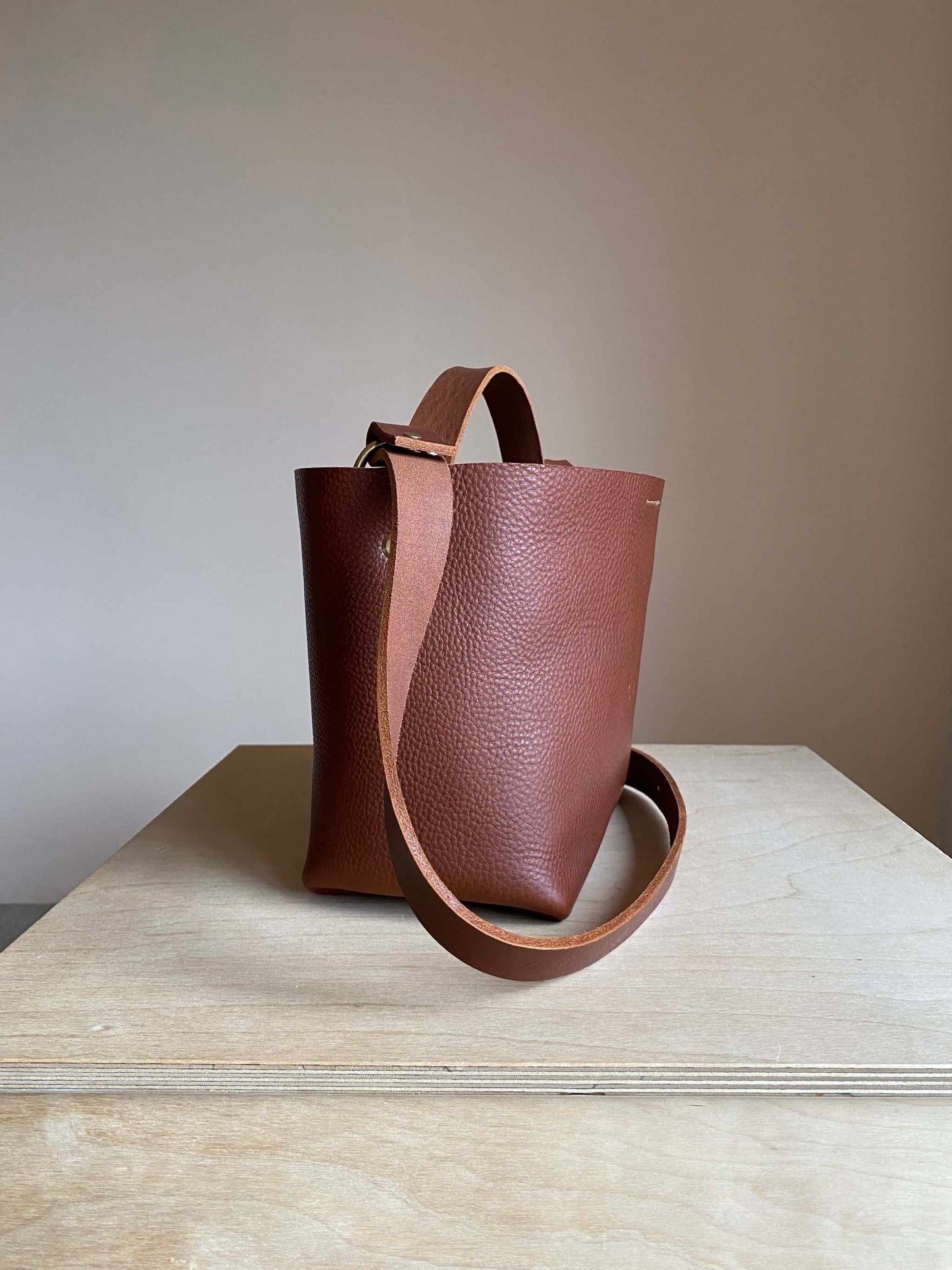 Basket Mini Leather Tote Bag by CARV in chestnut tan leather, showcasing a minimalist basket design with adjustable straps.