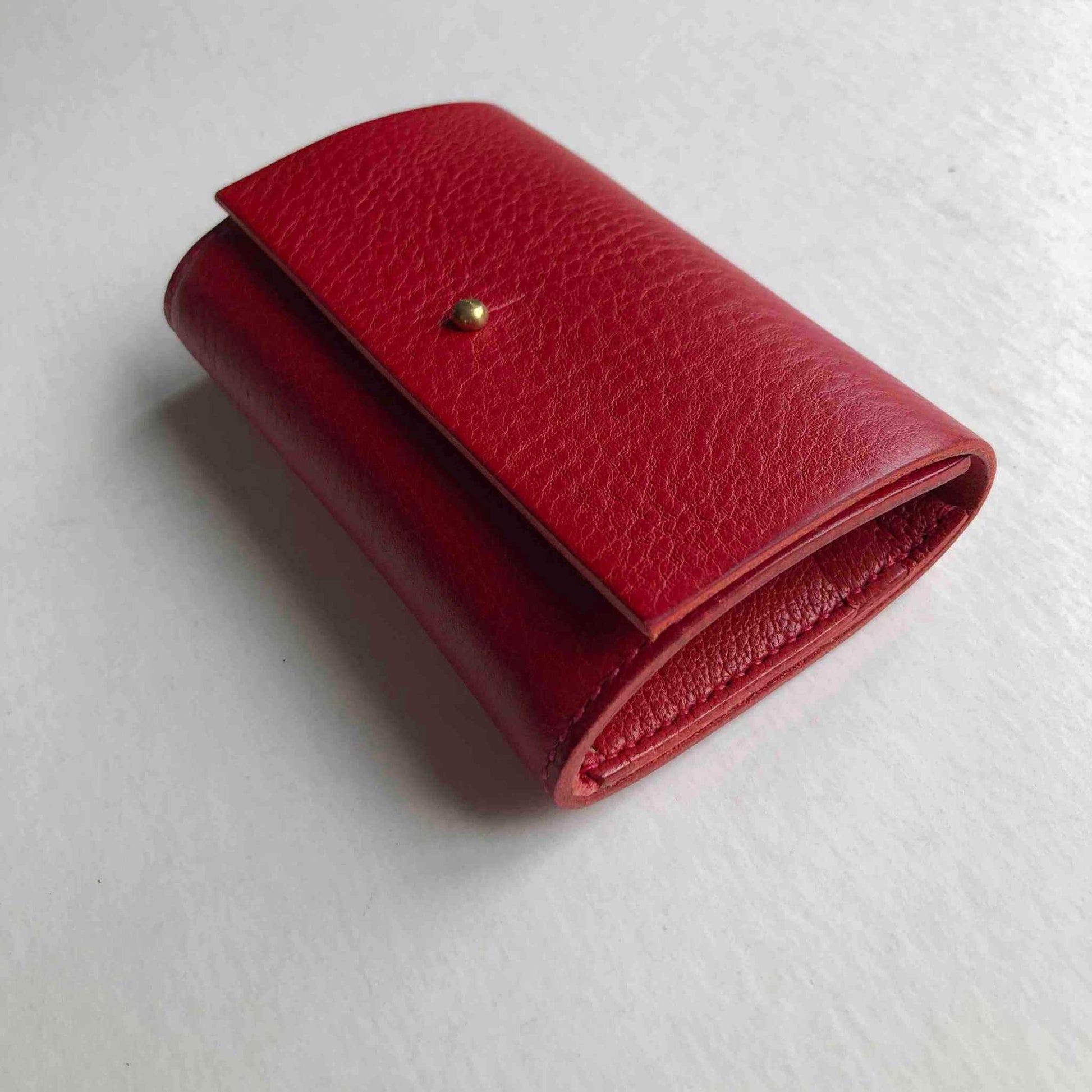 Nomad Mini Leather Women's Wallet in red, elegant minimalist design, handcrafted from sustainable leather, brass closure.