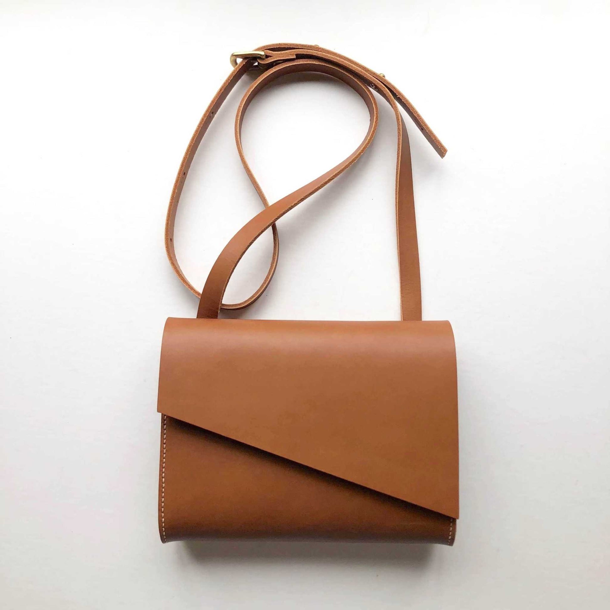 Tan leather crossbody bag with adjustable strap, handcrafted from premium vegetable-tanned leather.