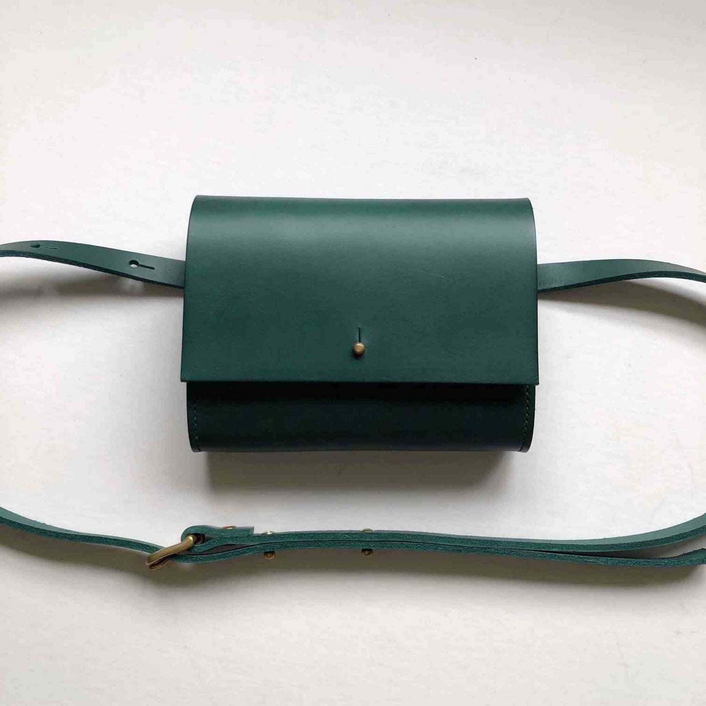 Handcrafted Sedna green leather belt bag with adjustable strap and minimalist design.