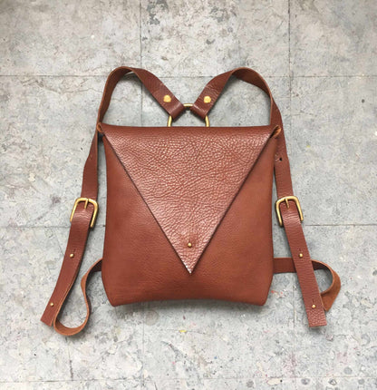 Drifter Leather Backpack in tan color with adjustable straps and minimalist envelope-style design.