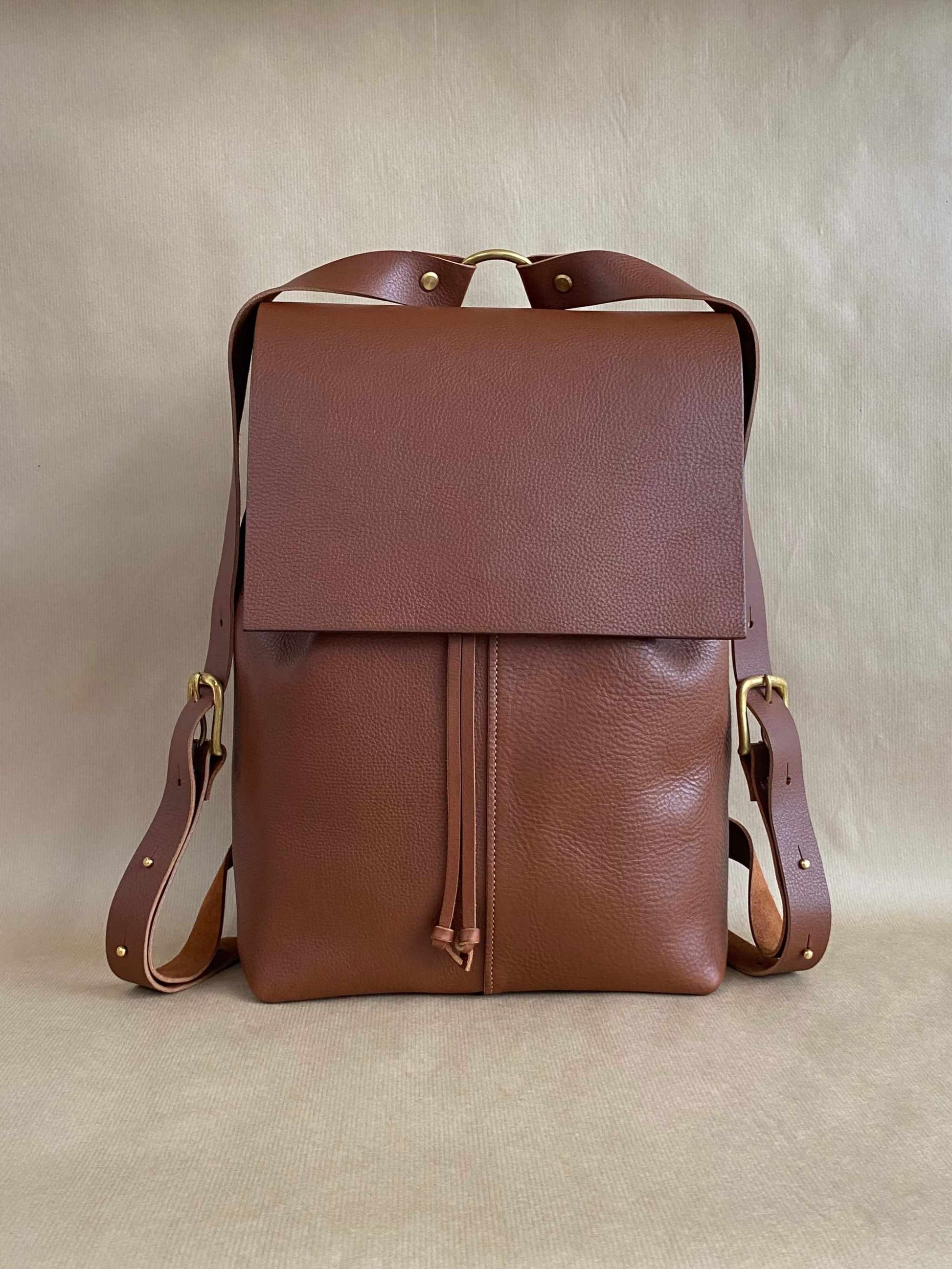 Tan leather backpack with a squared flap design, adjustable straps, crafted from premium leather by CARV.