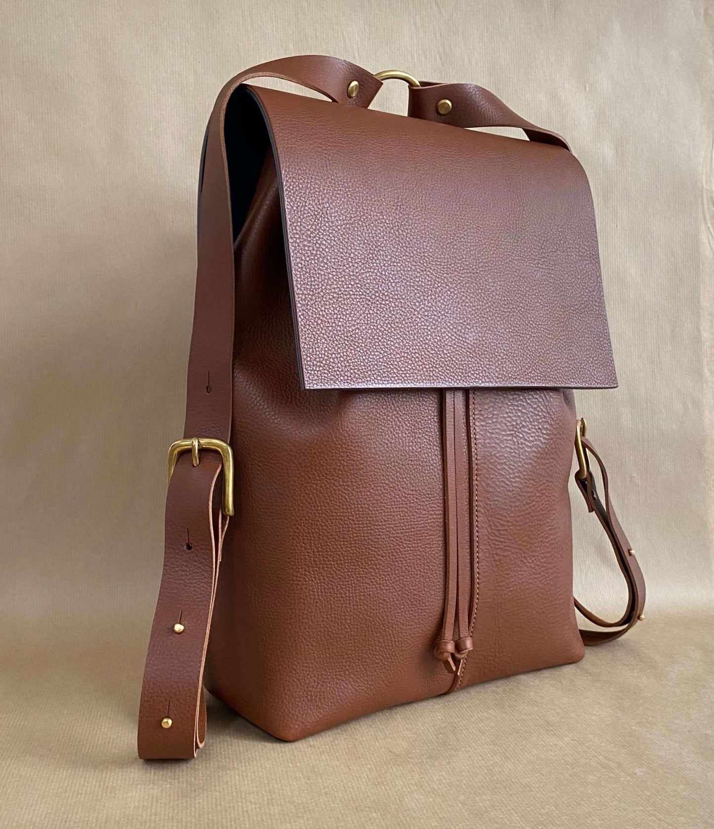 Nomad Tan Leather Backpack by CARV with adjustable straps and squared flap design.