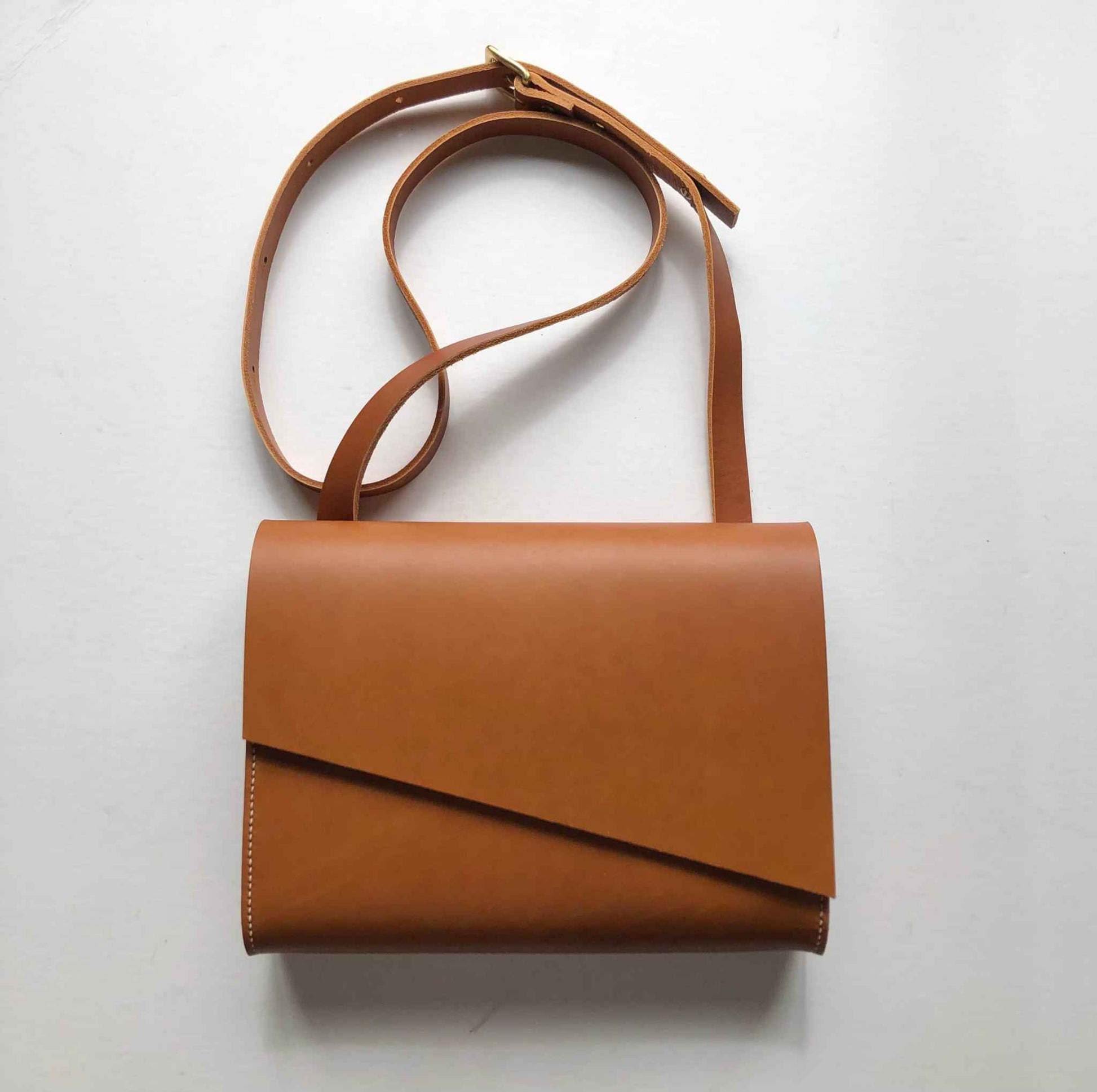 Tan Leather Crossbody Bag with asymmetrical flap and adjustable strap, handcrafted from sustainable vegetable-tanned leather.