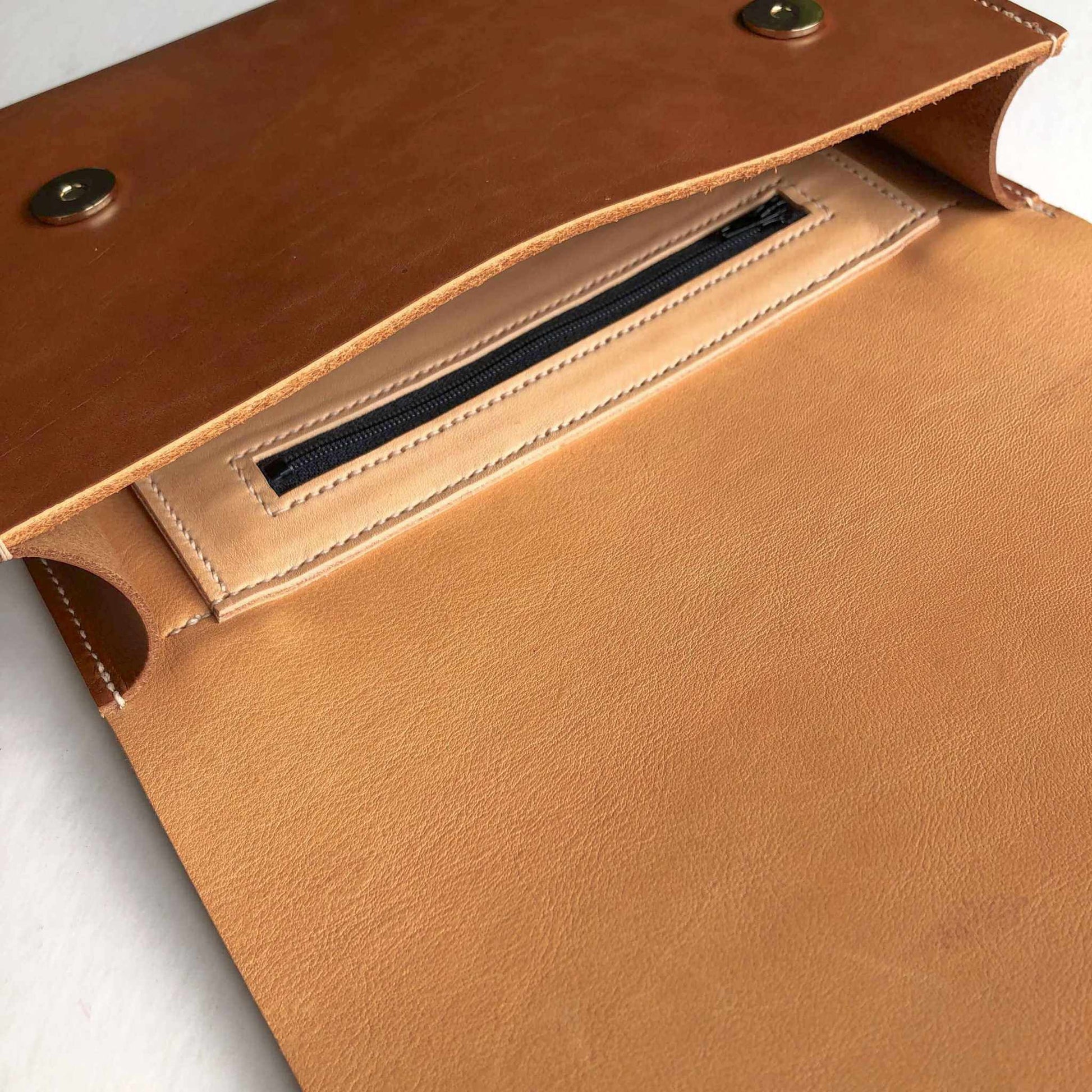 Inside view of Pioneer Midi Tan Leather Crossbody Bag with secure zip pocket and asymmetrical flap.