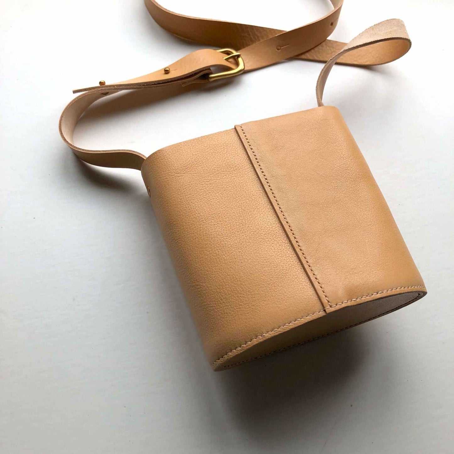 Oval Mini Leather Bag with natural raised grain leather and adjustable strap, handcrafted in the UK.