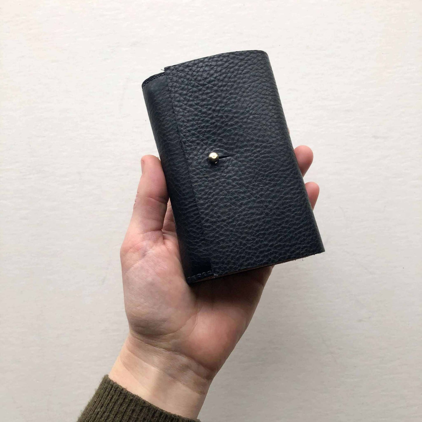 Nomad Mini Handmade Leather Wallet in Black with brass press stud, sustainable vegetable-tanned leather.