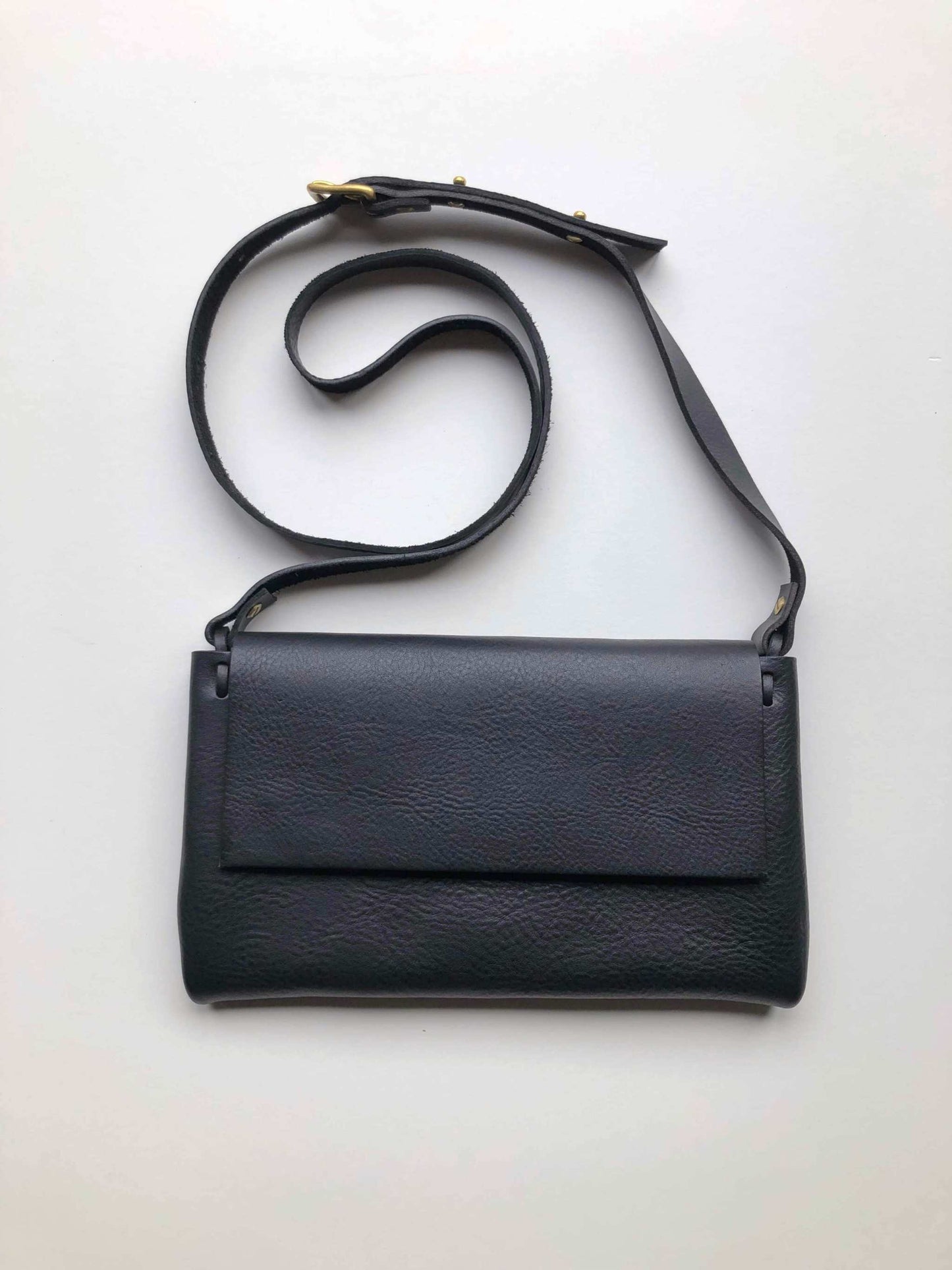 Black Fold Leather Crossbody Bag by CARV with adjustable strap and minimalist design.