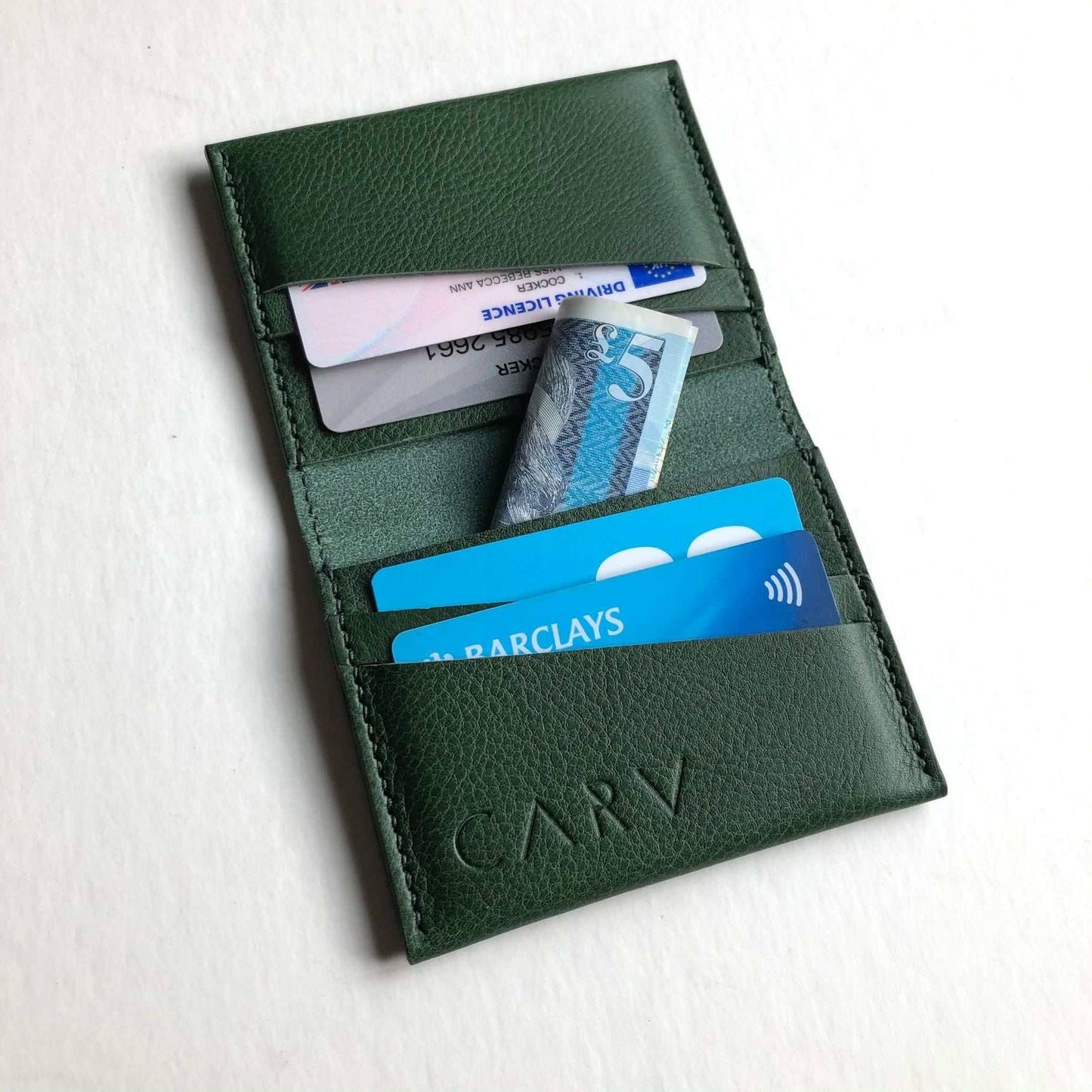 Fold green leather card wallet bifold with card slots and space for banknotes.