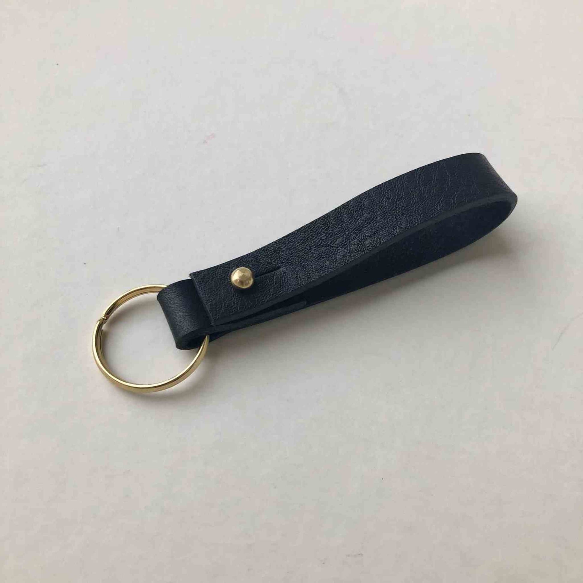 Nomad Personalised Leather Keyring with black vegetable-tanned leather and brass closure.