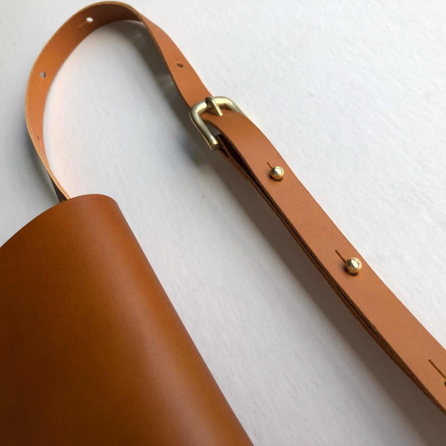 Sedna Tan Leather Belt Bag with brass buckle and adjustable strap, minimalist design.